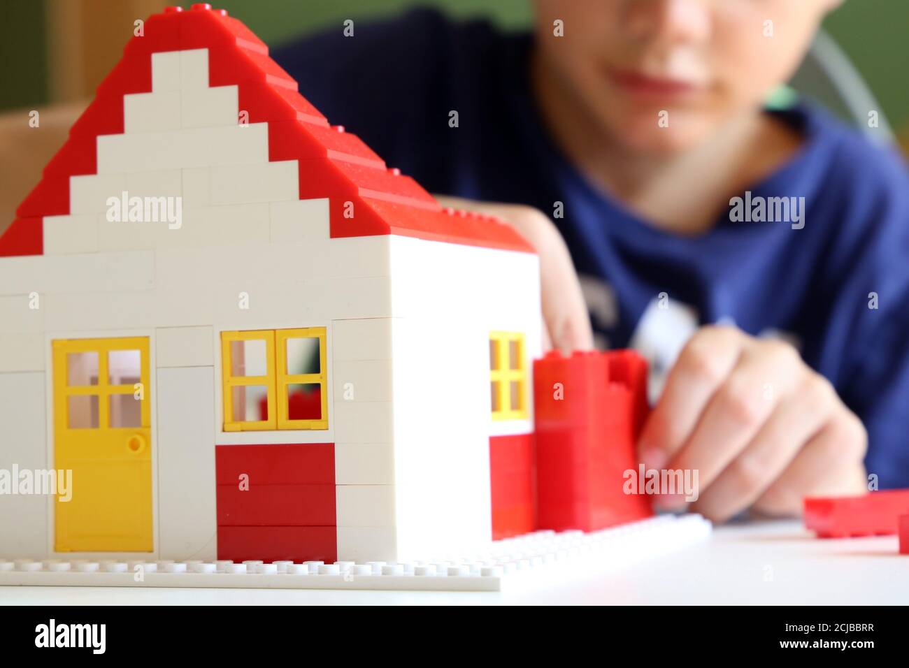 Symbol image: Boy builds a house with building blocks (Model released) Stock Photo