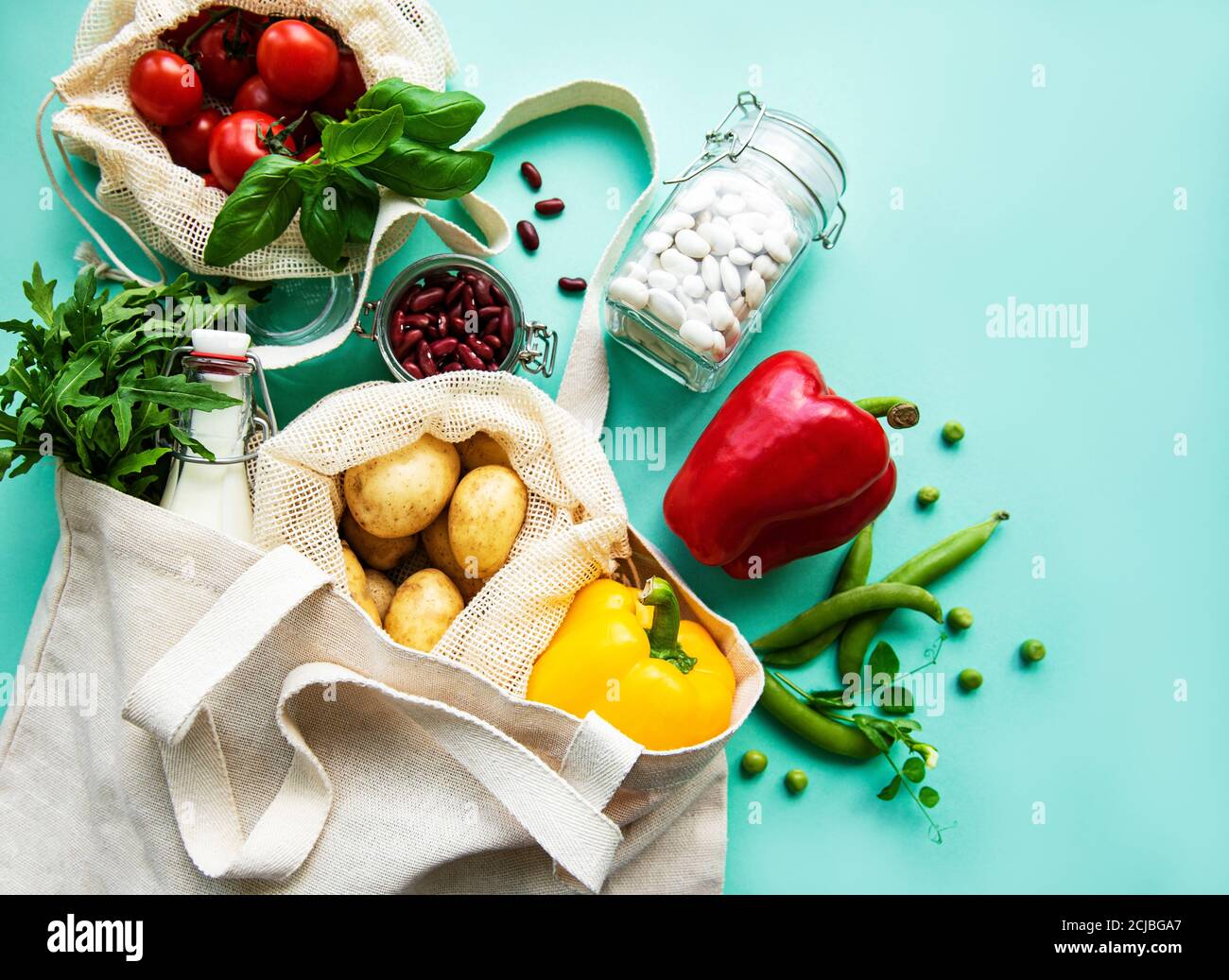 Fresh vegetables in eco cotton bags on green background. Zero waste ...