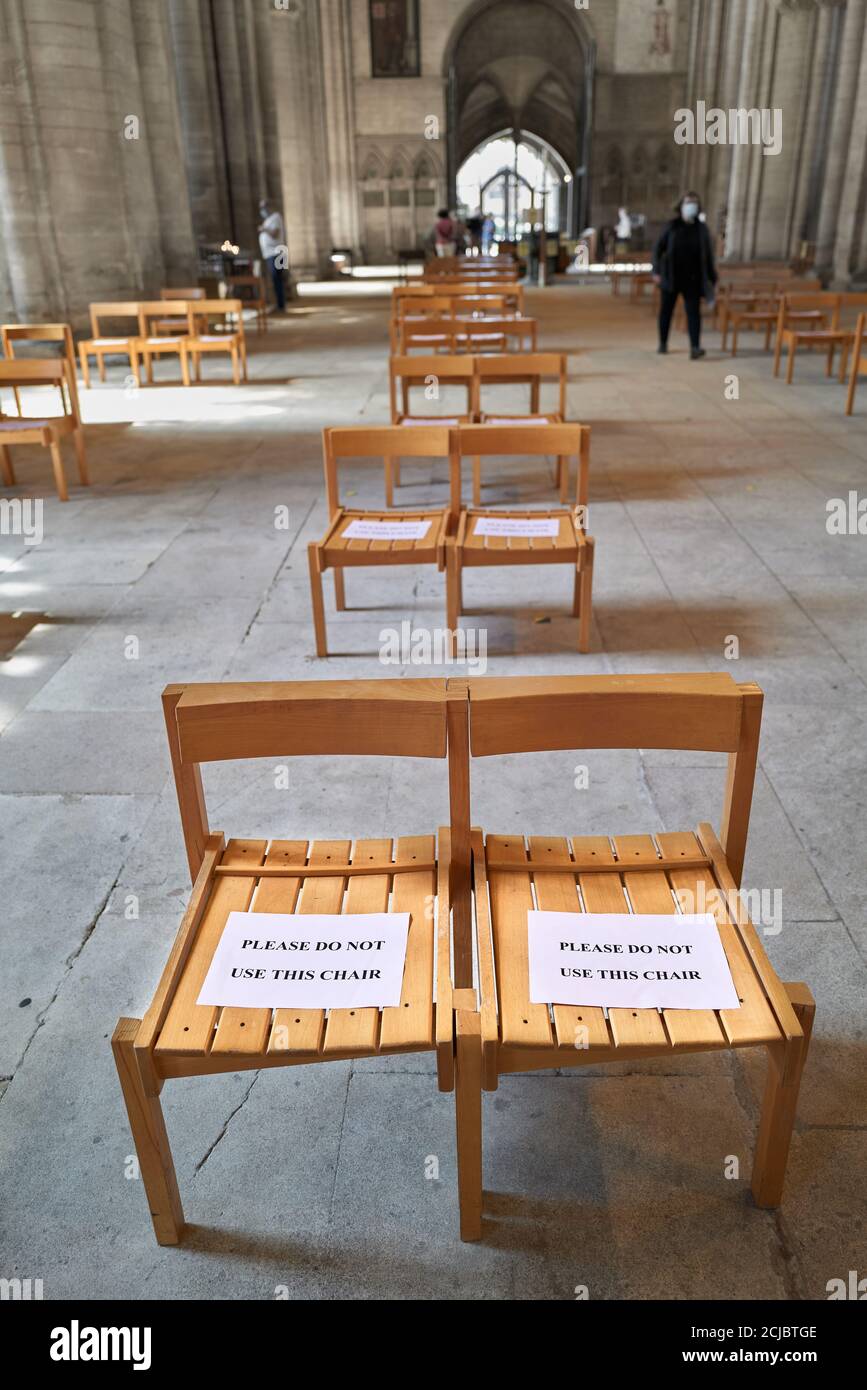 'Please do not use' notice on chairs in the nave of the norman built christian cathedral at Peterborough, England, during the coronavirus crisis, 2020. Stock Photo