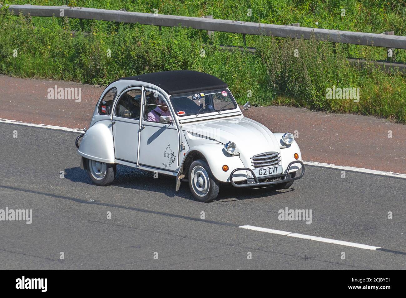 1990 90s nineties white French Citroën 2 CV6 Special; Vehicular traffic moving vehicles, cars driving. French vehicle on UK roads, motors, motoring on the M6 motorway highway network. Stock Photo