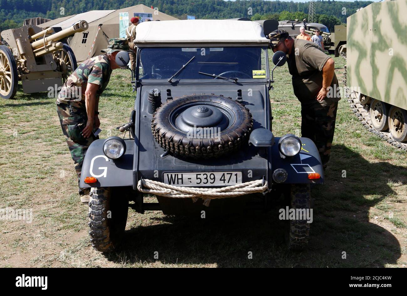 Visitors stand beside a German World War II Volkswagen Type 82 "Kuebelwagen"  car at the 8th Convoy-to-Remember meeting in the village of Birmenstorf,  Switzerland August 9, 2019. REUTERS/Arnd Wiegmann Stock Photo -
