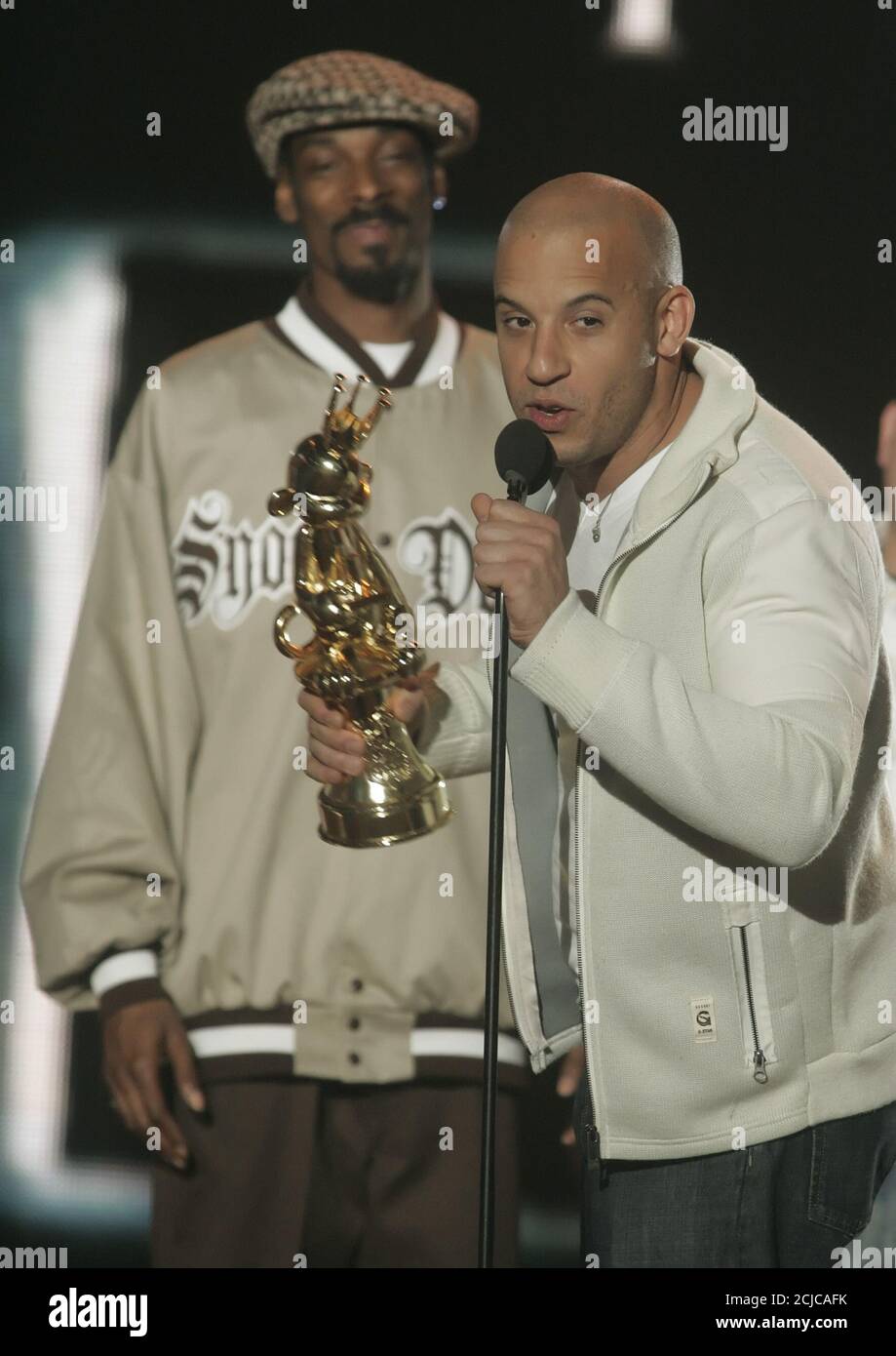 Actor Vin Diesel Accepts The Best Game Based On A Movie Award For The Chronicles Of Riddick Escape From Butcher Bay As Show Host Snoop Dogg Background Looks On At The Spike