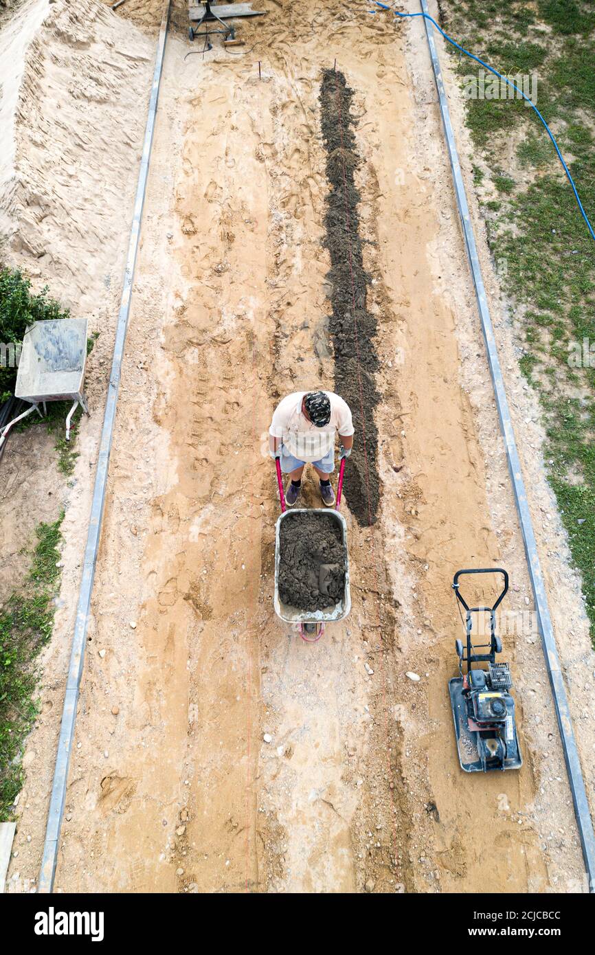 workers lay paving tiles top view from a drone. Stock Photo