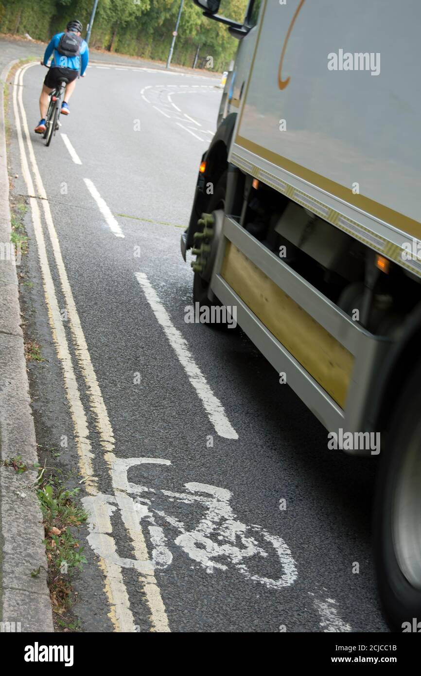 lorry approaching a male cyclist in a very narrow advisory cycle lane, in barnes, southwest london, england Stock Photo