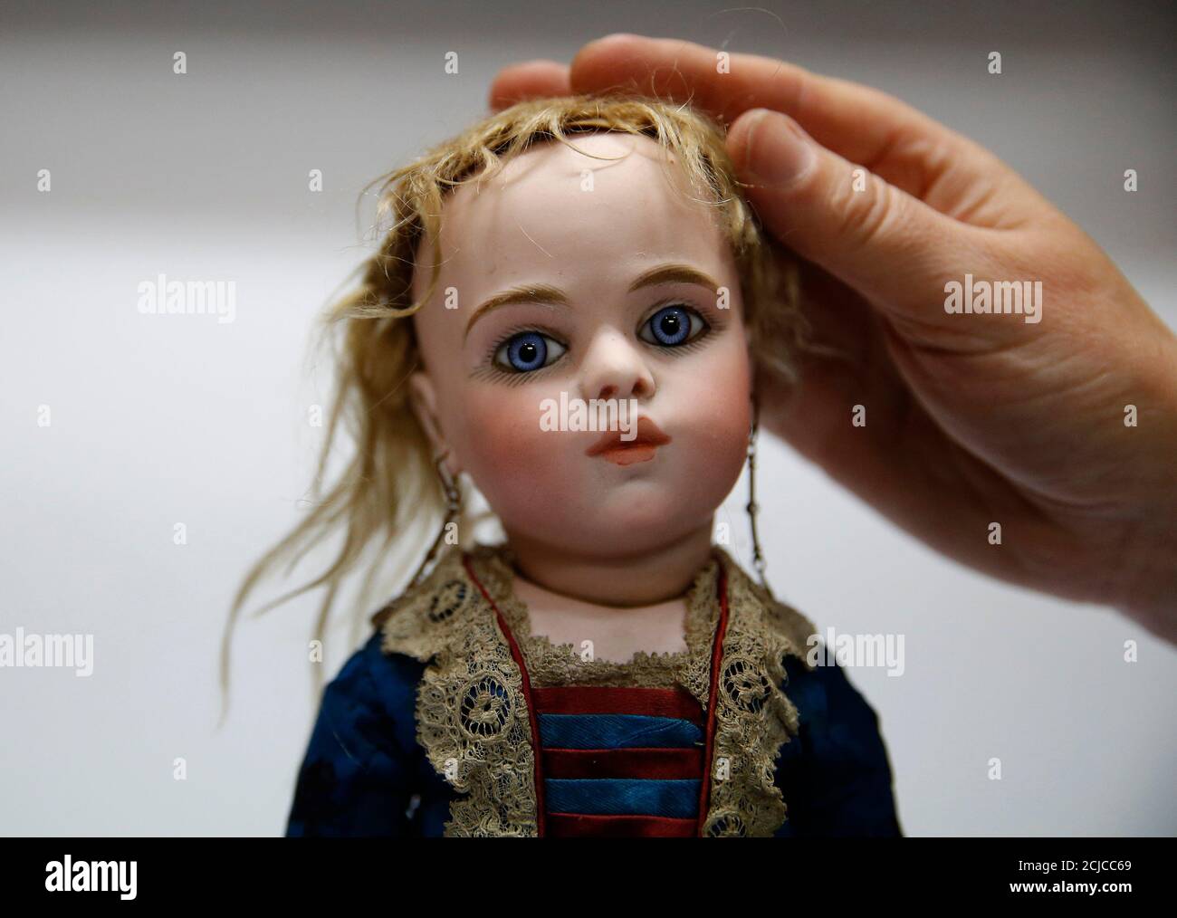 A worker adjusts the hair on a French bisque doll at the Vectis auction  house in Stockton-on-Tees, Britain November 23, 2015. The doll from  approximately 1880 is estimated to sell for 6000-8000