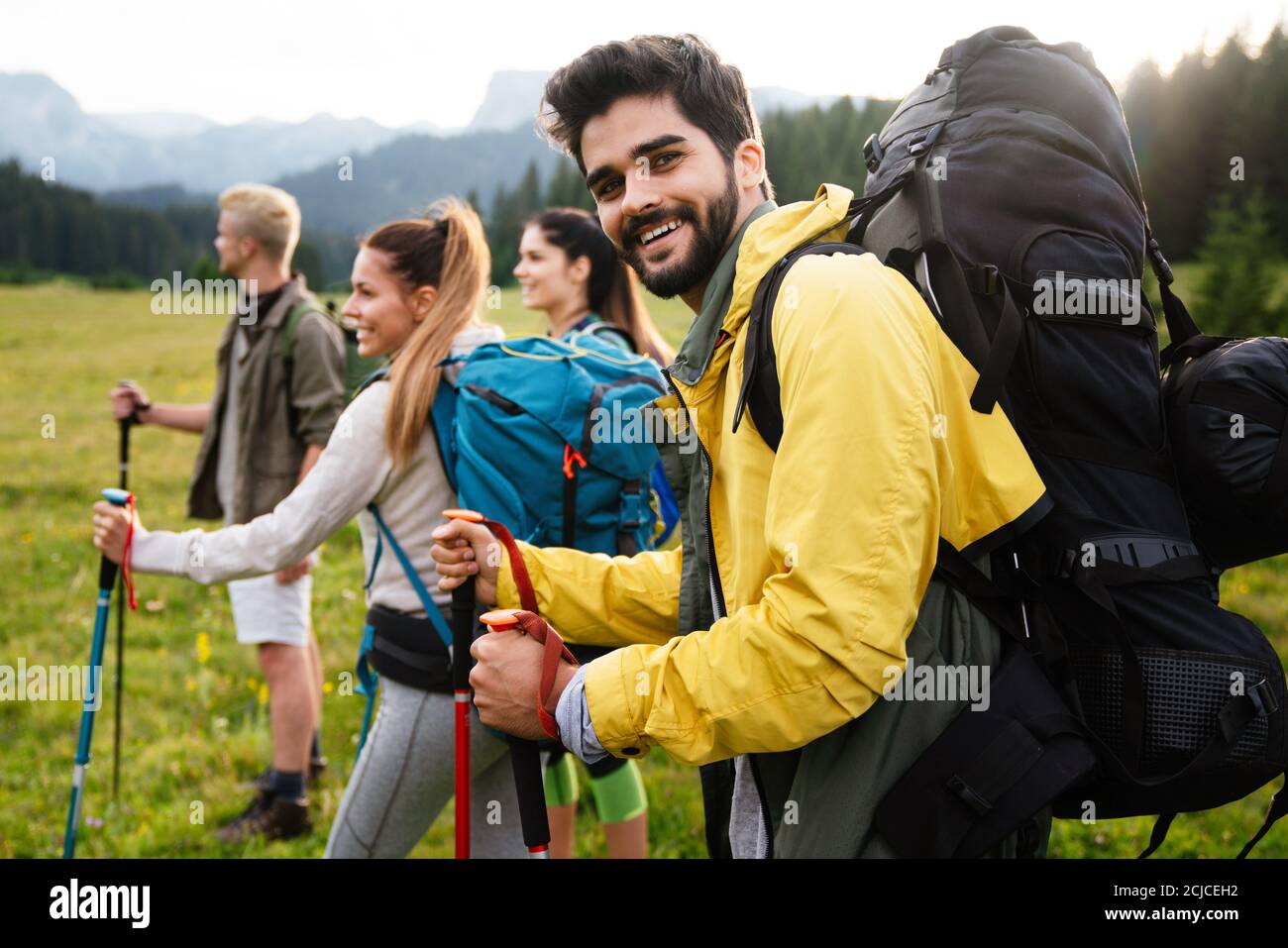 Group of young friends hiking in countryside. Multiracial happy people ...