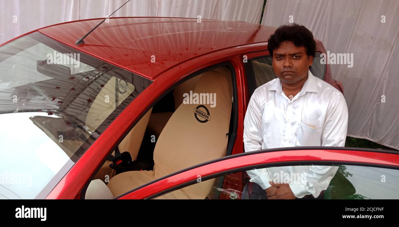 DISTRICT KATNI, INDIA - SEPTEMBER 16, 2019: An indian automobile male sales manager presenting NISSAN brand car model for street promotion events. Stock Photo
