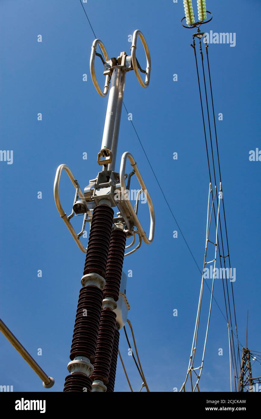 Electric unit and insulators (isolators) of transformer substation on power generating plant. High-voltage equipment. Blue sky background Stock Photo
