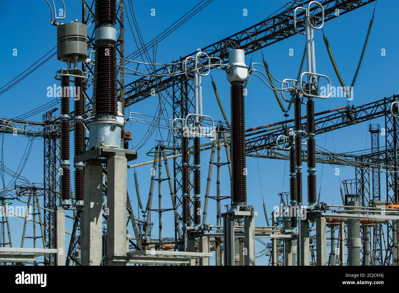 High-voltage equipment. Distribution substation of power generating plant. Transformer station. Blue sky background. Stock Photo