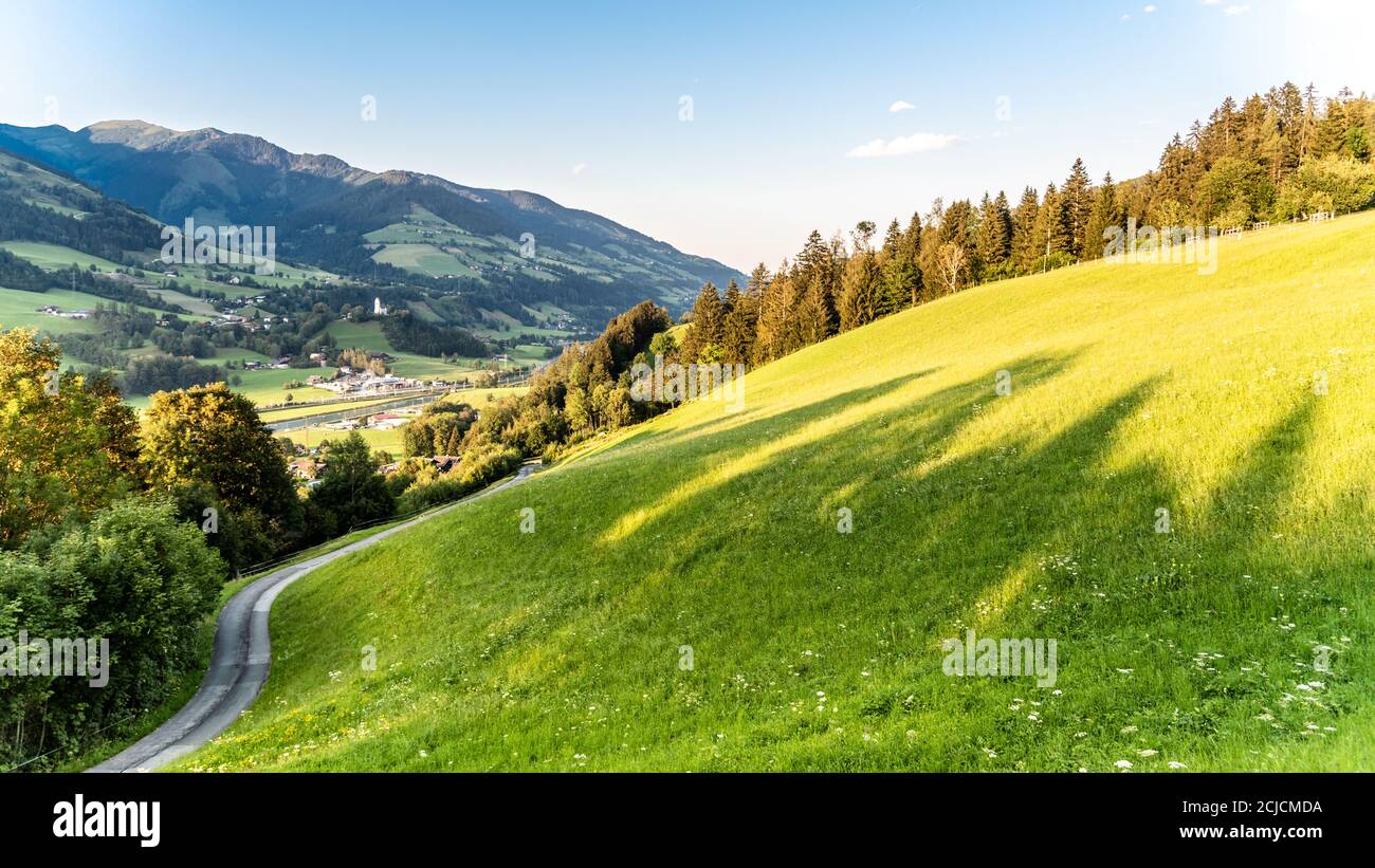 Romantic sunset in the mountains. Green alpine meadows and high peaks of Austrian Alps. Salzach River Valley, Pinzgau, Austria. Stock Photo
