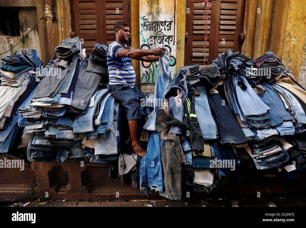 A vendor checks and arranges used jeans 