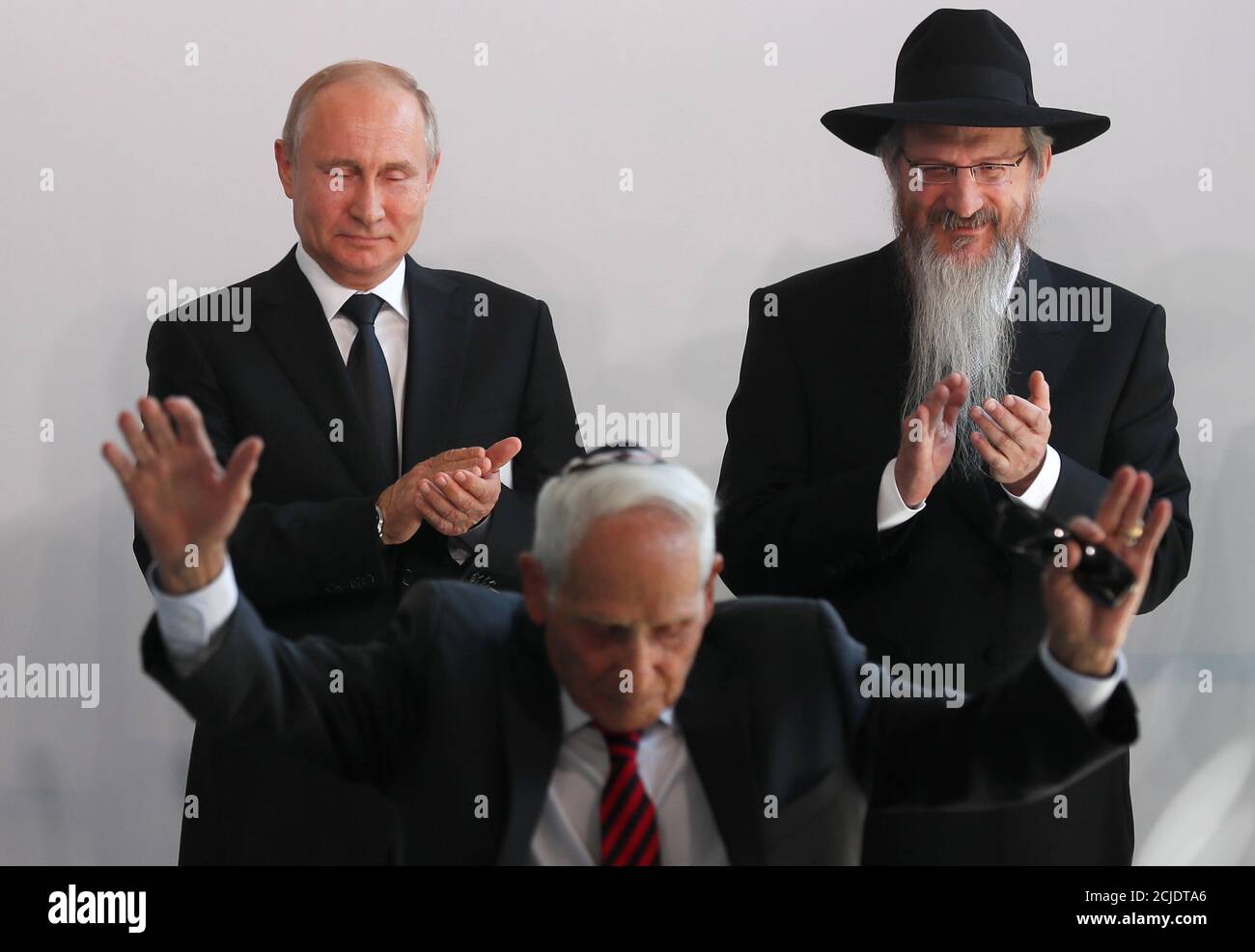 russias-president-vladimir-putin-l-chief-rabbi-of-russia-berel-lazar-r-and-veteran-and-former-member-of-a-partisan-group-aron-bielski-attend-a-ceremony-unveiling-a-monument-to-heroes-of-resistance-in-concentration-camps-and-ghettos-during-world-war-two-at-the-jewish-museum-and-tolerance-centre-in-moscow-russia-june-4-2019-sergei-ilnitskypool-via-reuters-2CJDTA6.jpg