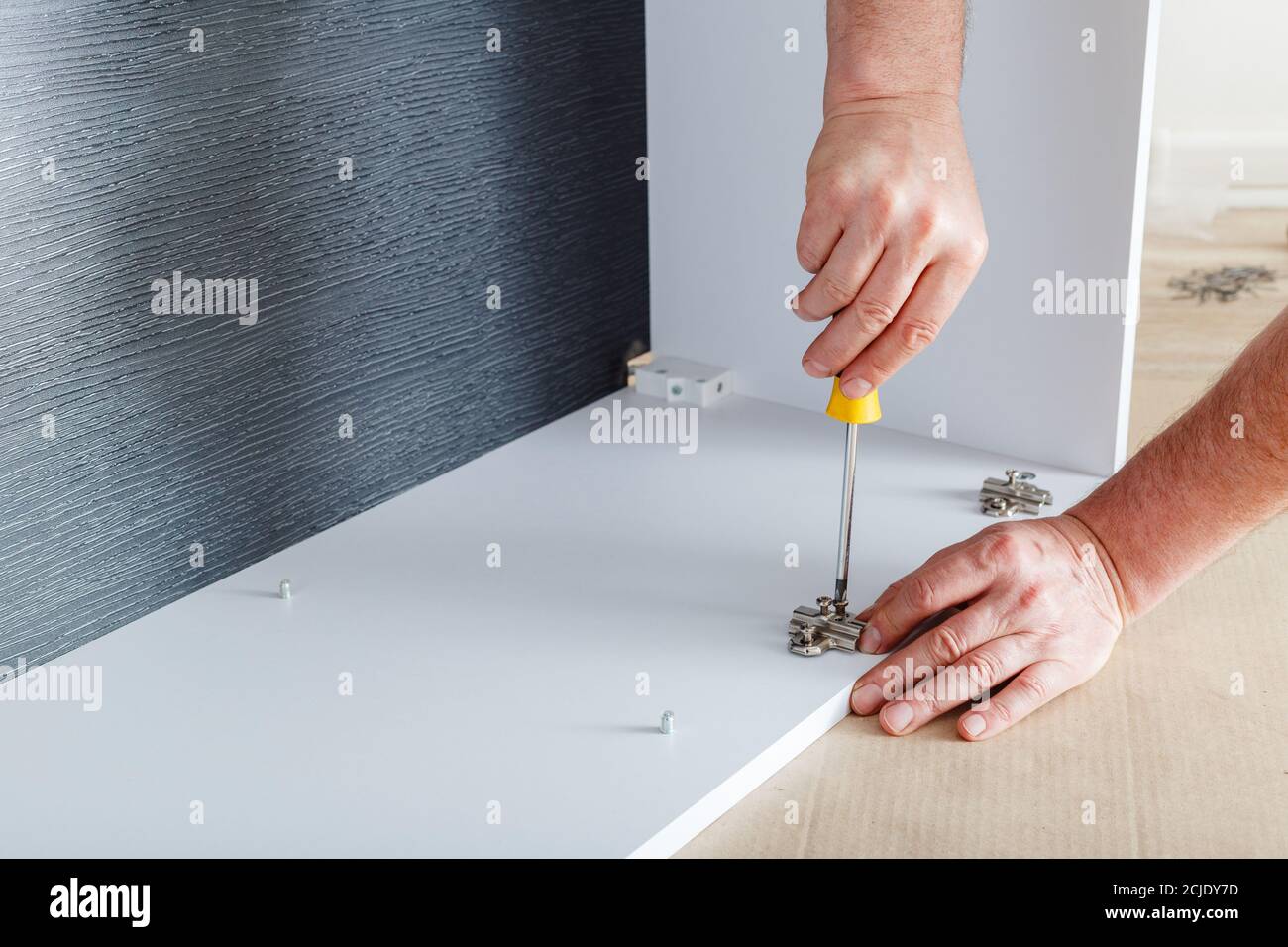 Joiner collects furniture using hand tools screwdriver. Furniture