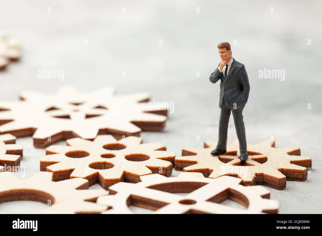 Business Analysis. Audit of the company. A businessman in a suit stands on gears as a symbol of business processes in the company. Stock Photo