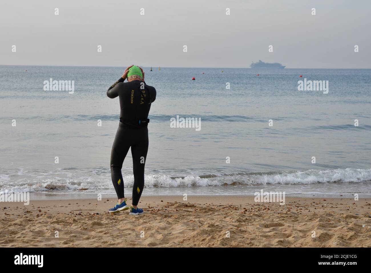 Sea swimmer in a wetsuit preparing to enter the water.