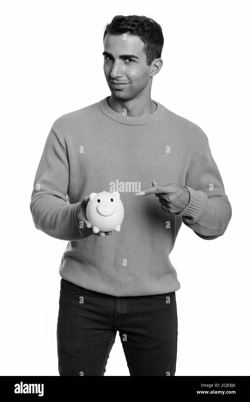 Young handsome Iranian man holding piggy bank and pointing finger Stock ...