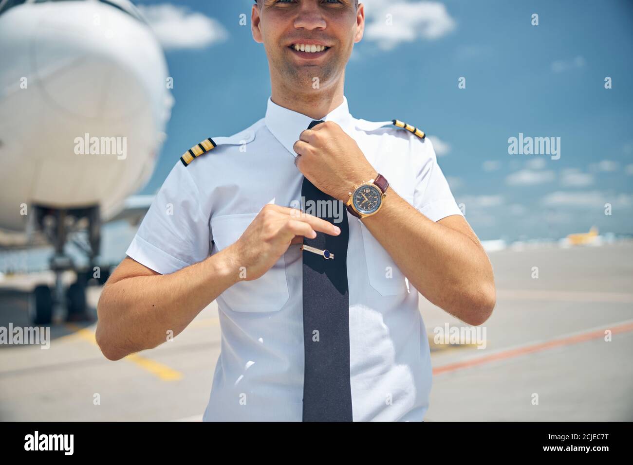 Handsome pilot in command adjusting his tie at airport Stock Photo Alamy Handsome pilot in command adjusting his tie at airport Stock Photo Alamy