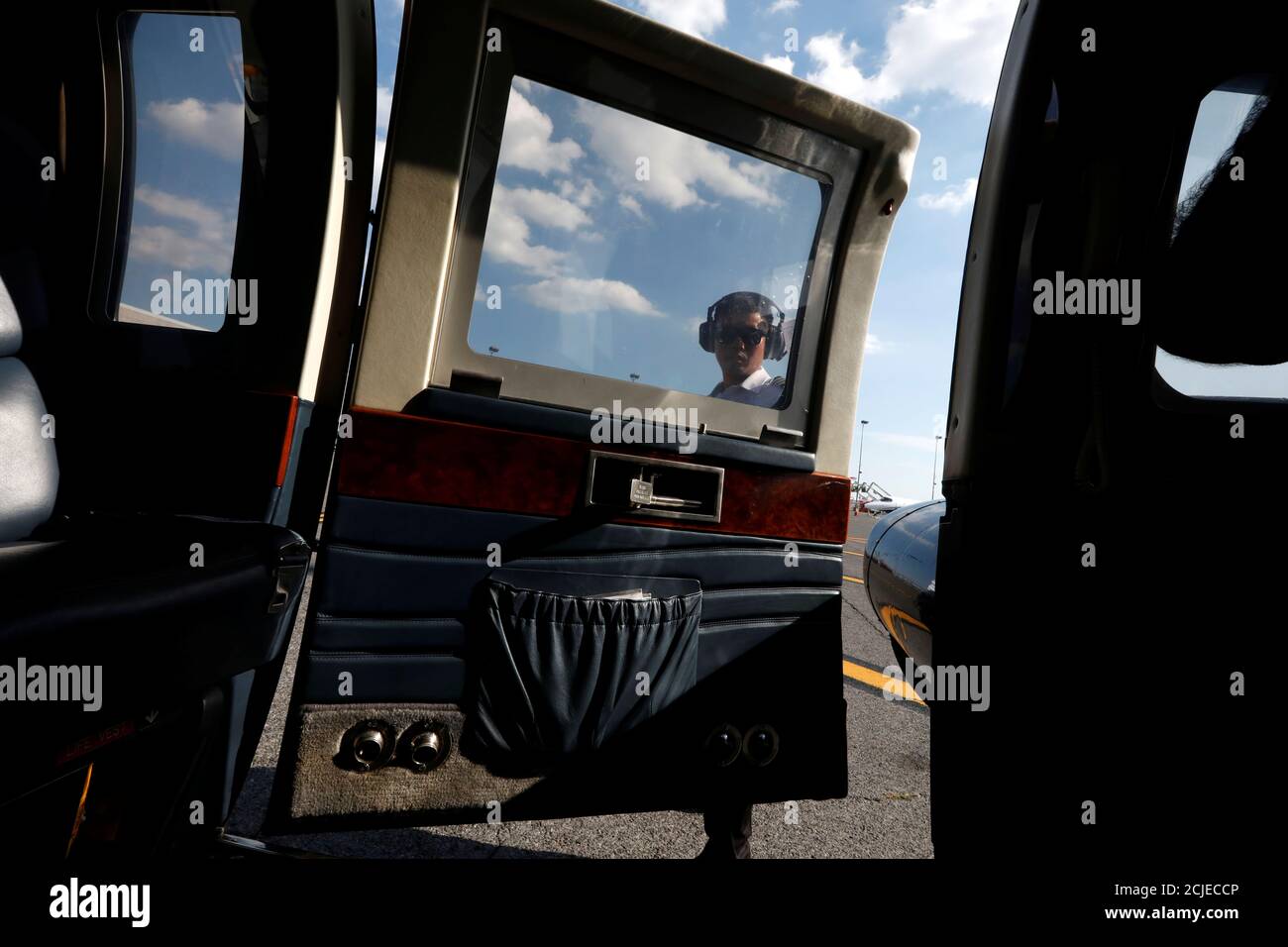 A pilot opens the door to a helicopter operated by Uber Copter, a 
