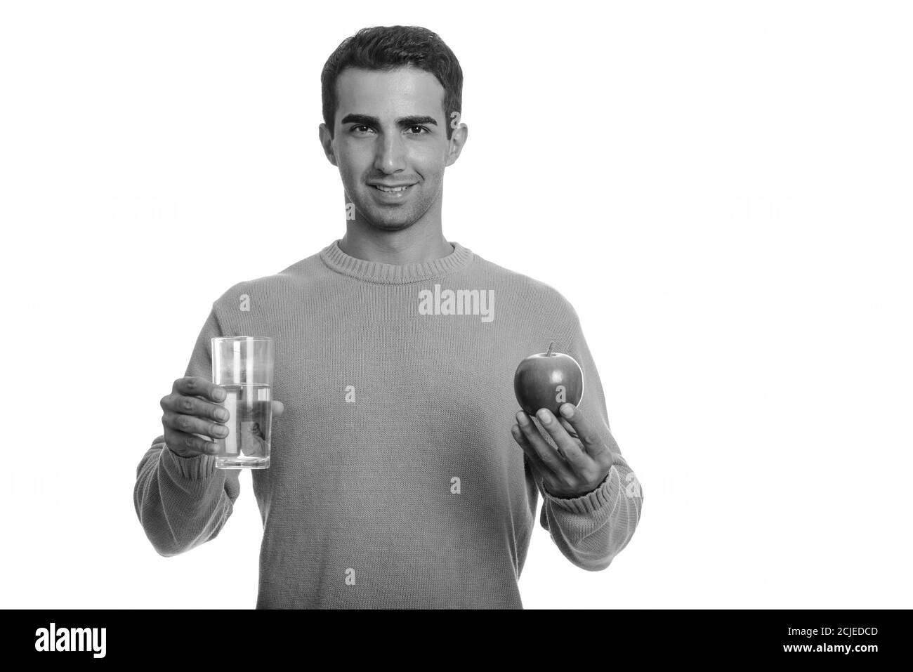 Young happy Iranian man holding red apple and glass of water Stock ...