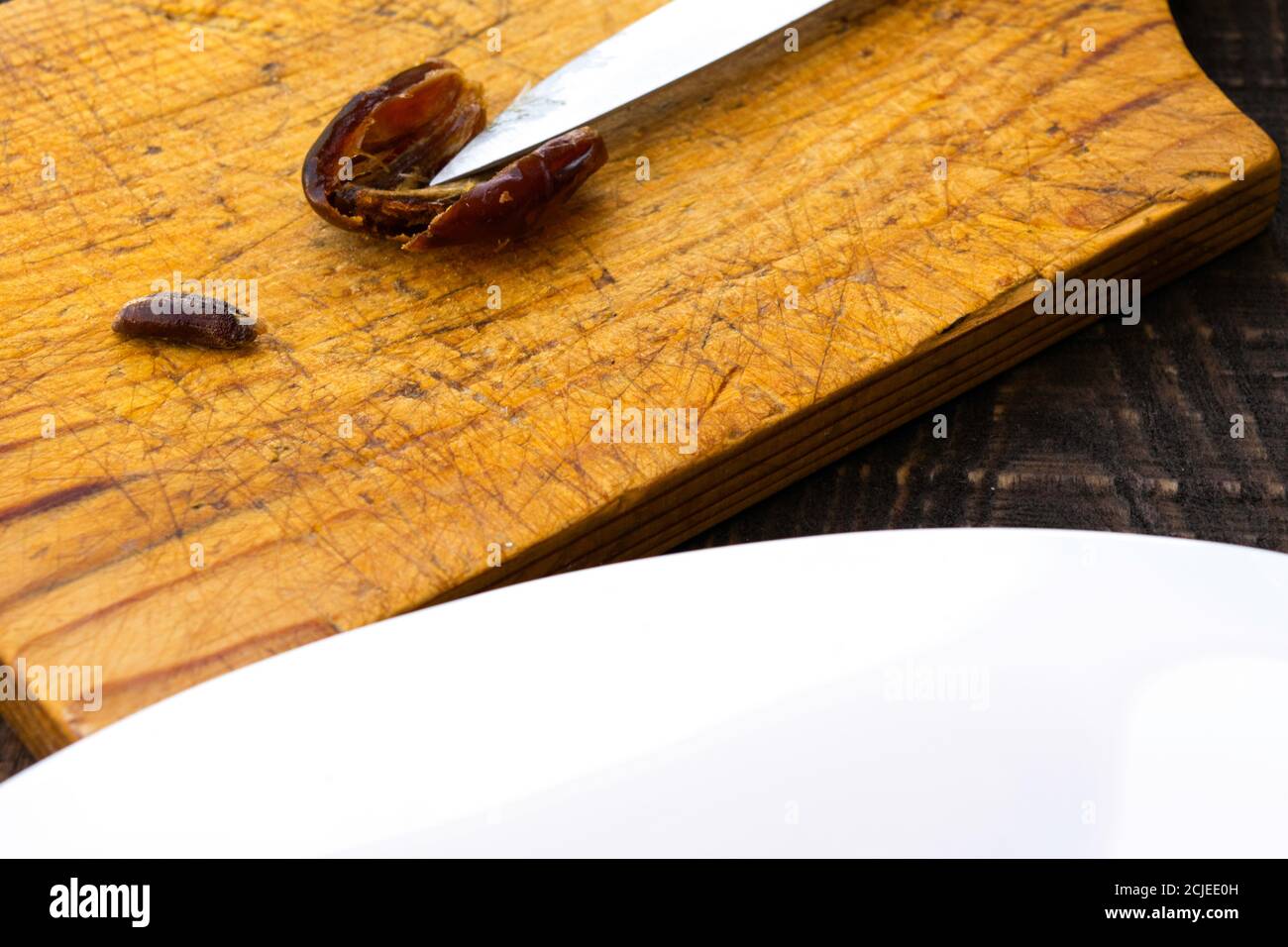 Hushaf - date milk, a traditional dish of Ramadan, cooking, ingredients, cut pitted dates, a knife and a date stone lie on a cutting board, there is t Stock Photo