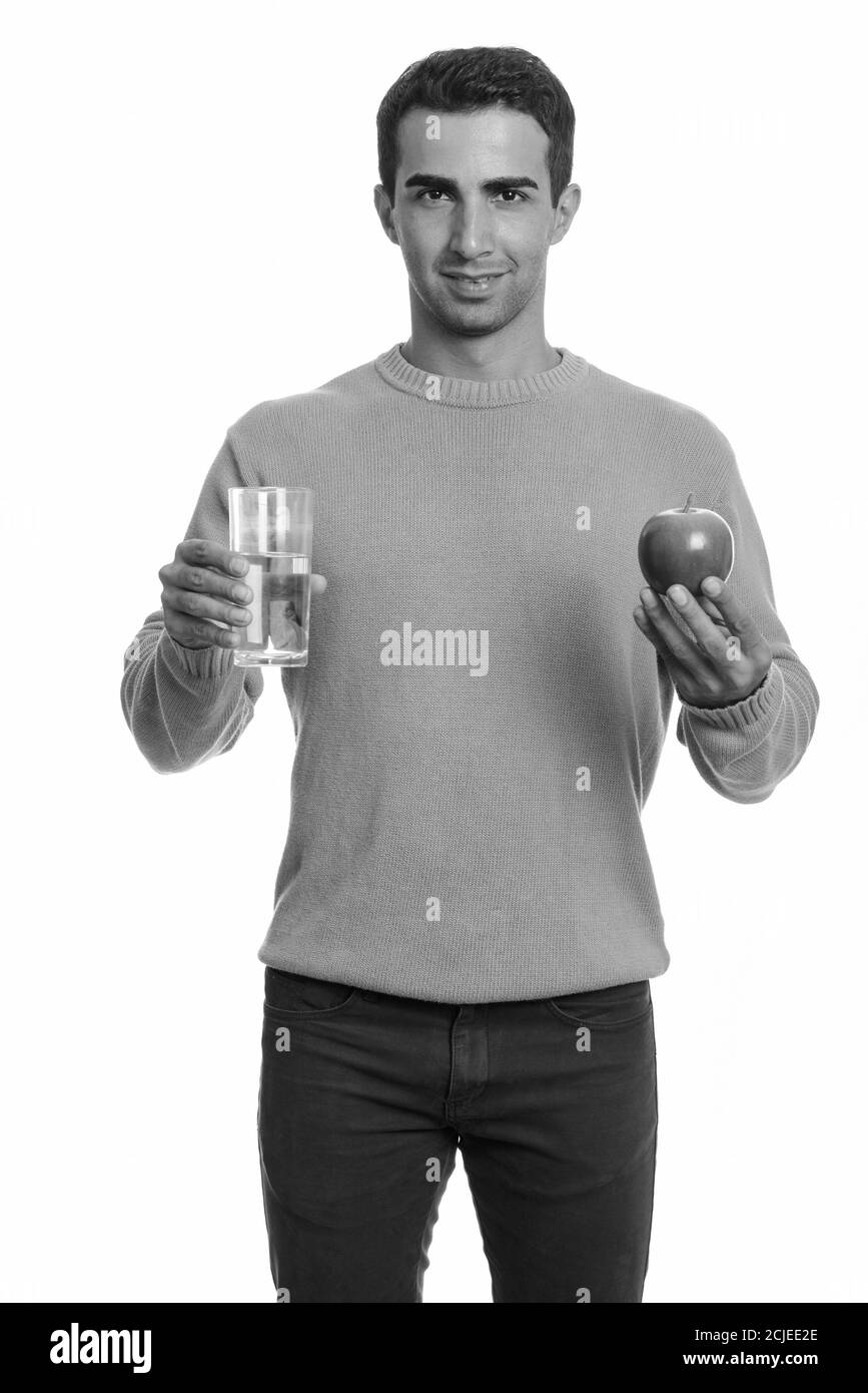 Young happy Iranian man holding red apple and glass of water Stock ...