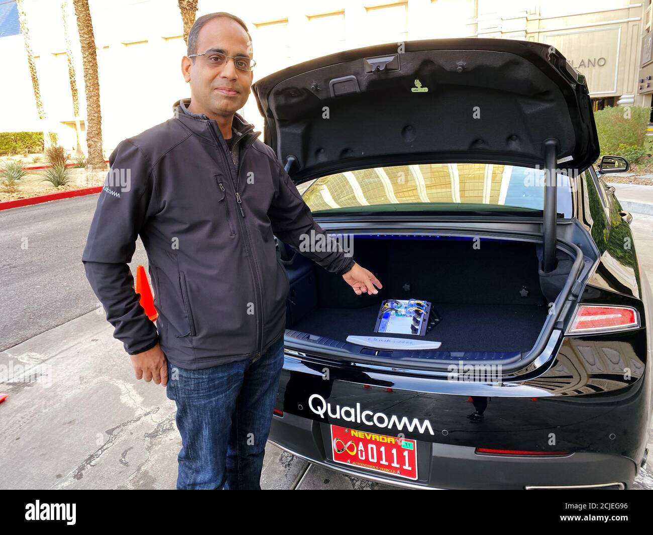 Dheeraj Ahuja, Senior Director Of Engineering at Qualcomm, shows the new  Snapdragon Ride autonomous driving computing system in the trunk of a demo  car at the Consumer Electronics Show (CES) in Las