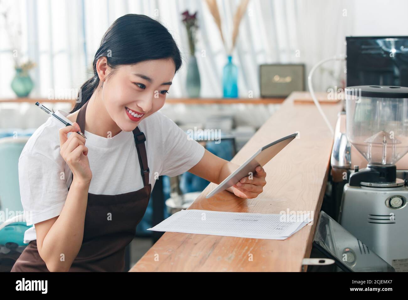 Coffee shop attendant with tablets Stock Photo