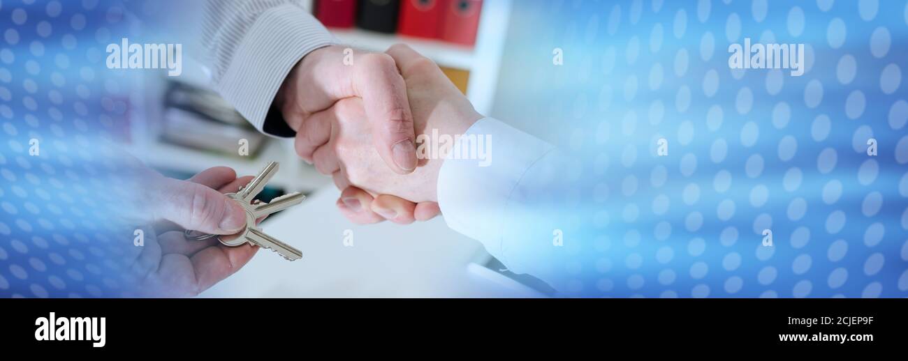 Realtor shaking hands with his client by delivering the keys, closeup ...
