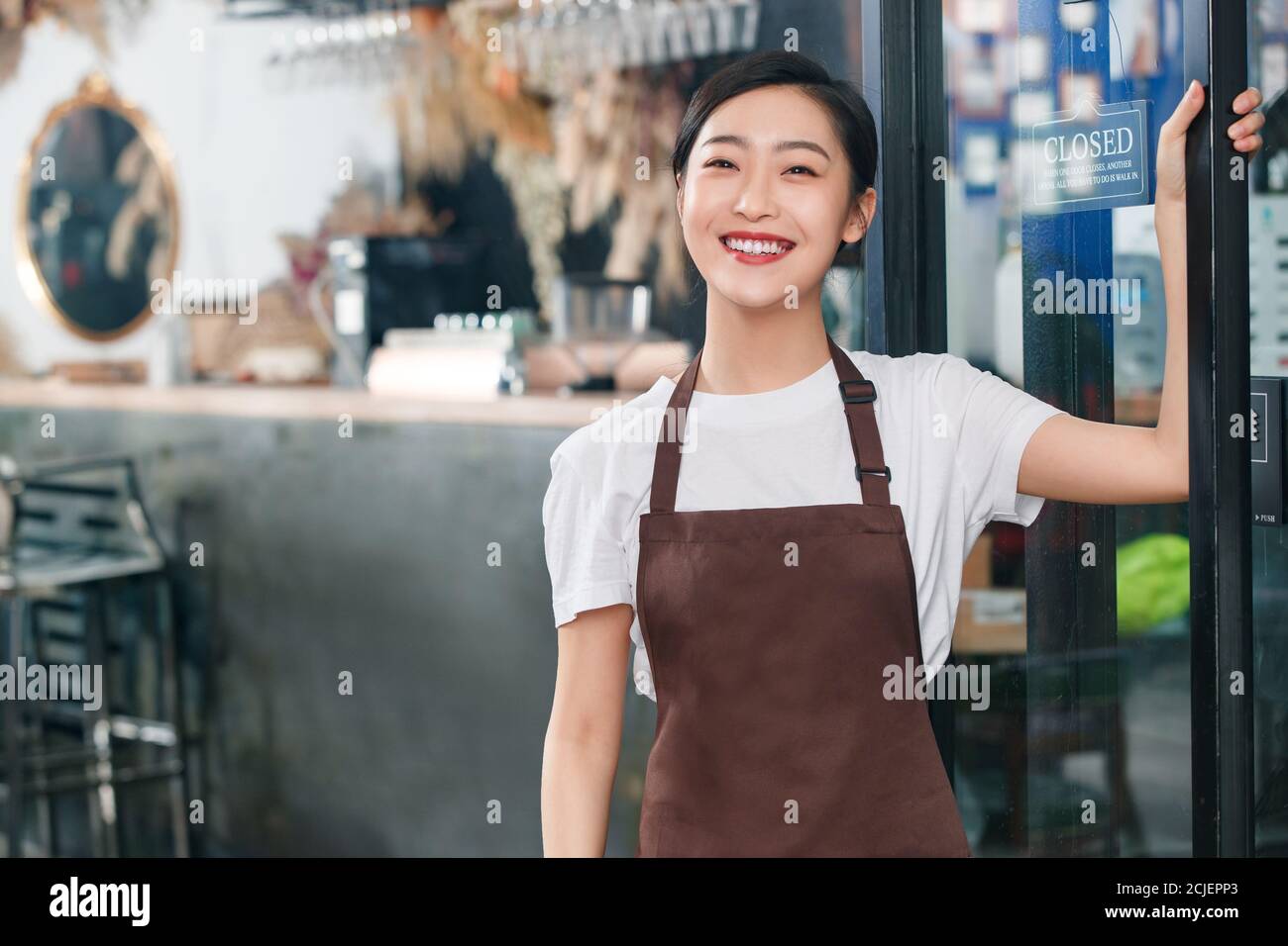 Standing at the door of the cafe waitress Stock Photo