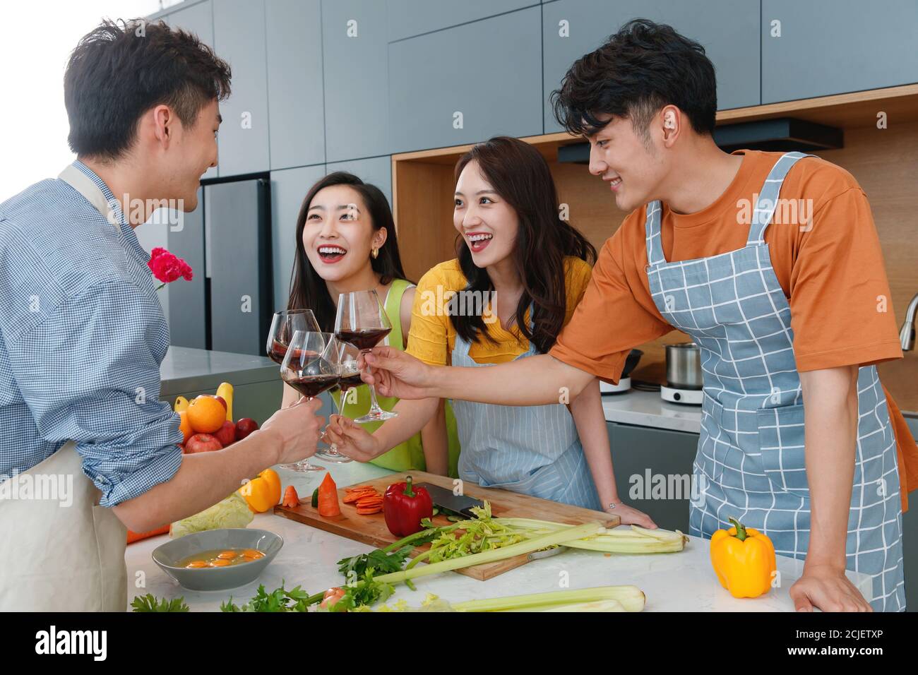 Happy young cook while drinking red wine Stock Photo