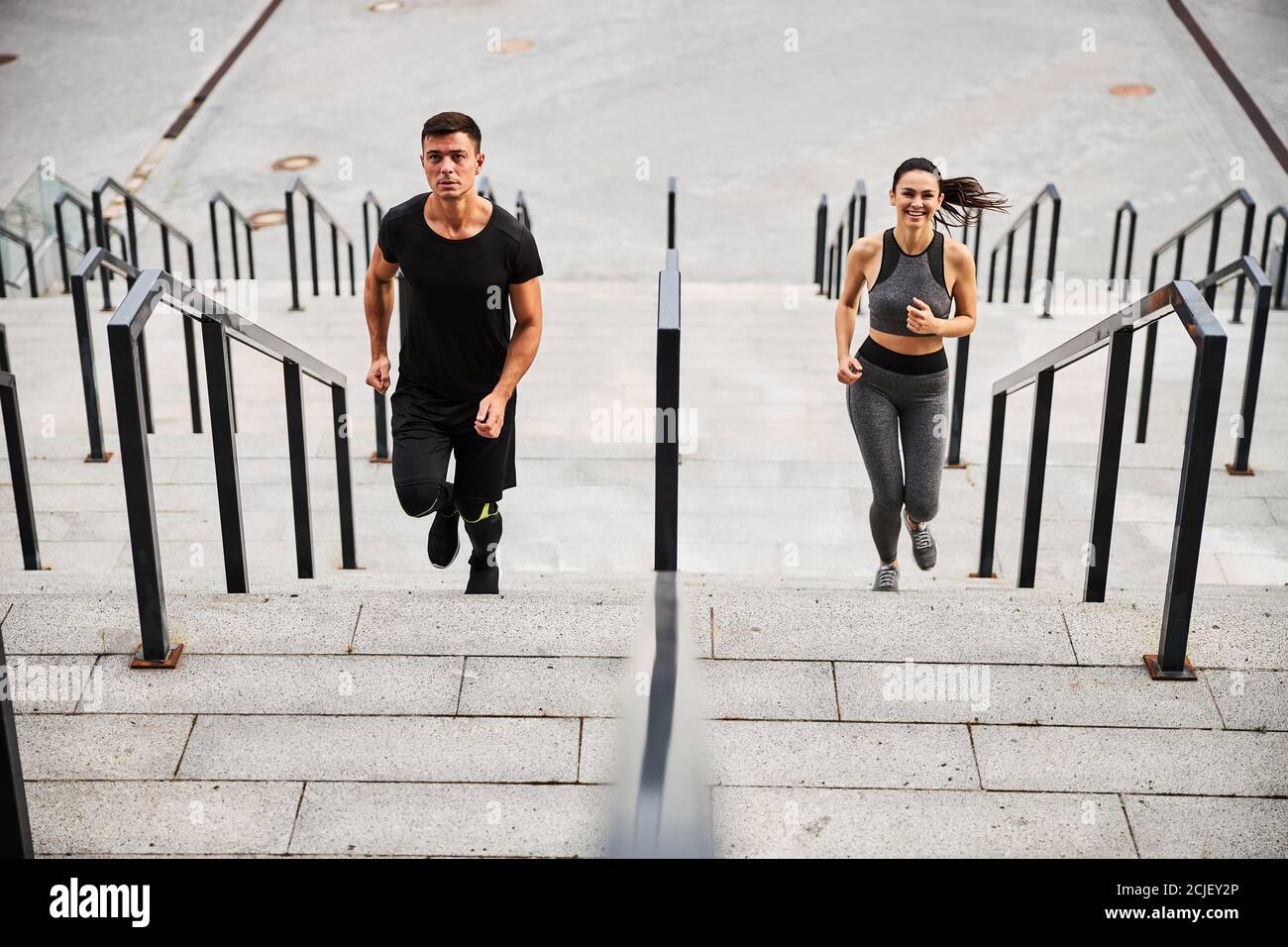 Happy sporty couple going jogging on stairs Stock Photo - Alamy