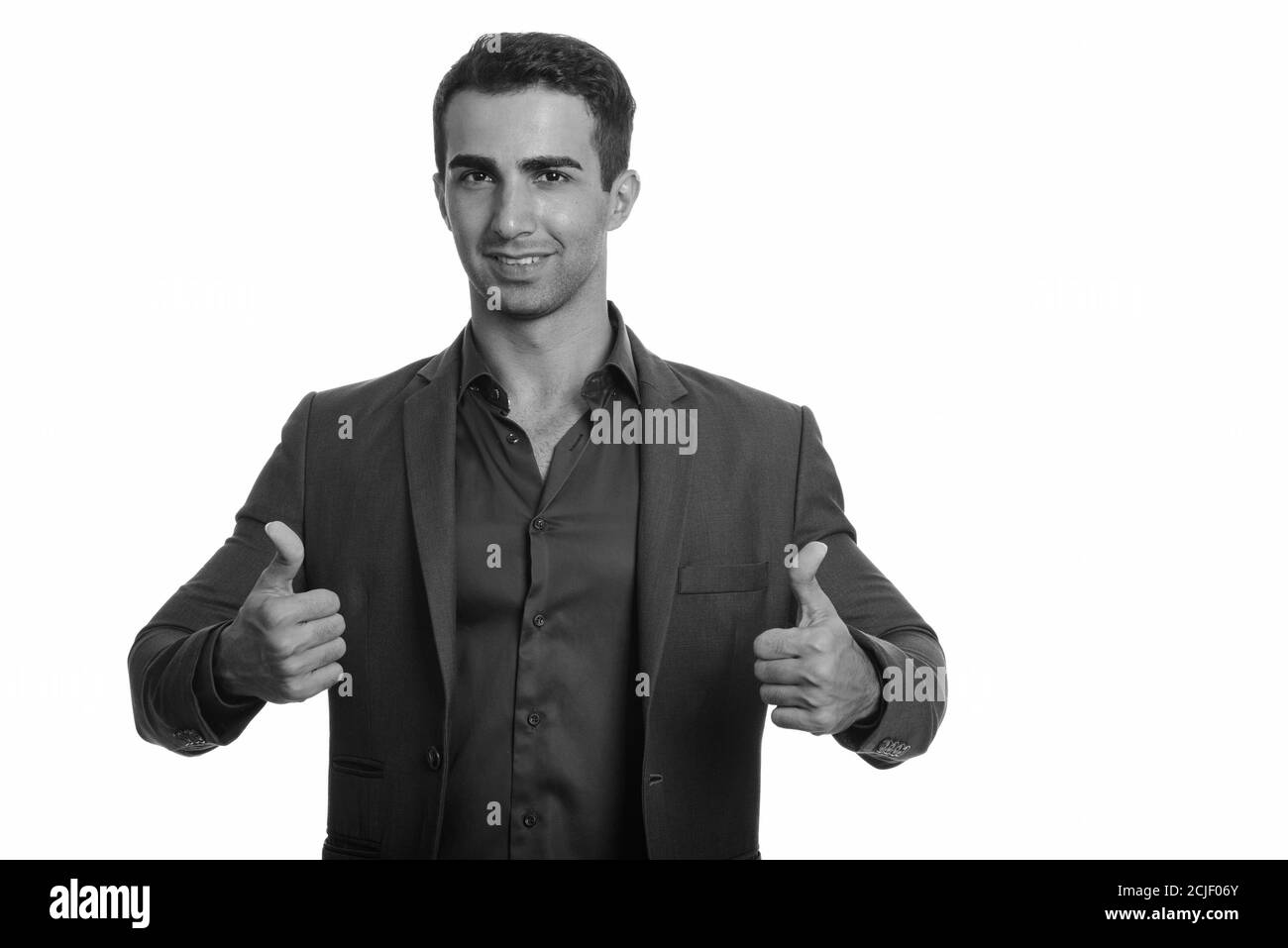 Portrait of happy young handsome Persian businessman giving thumbs up ...