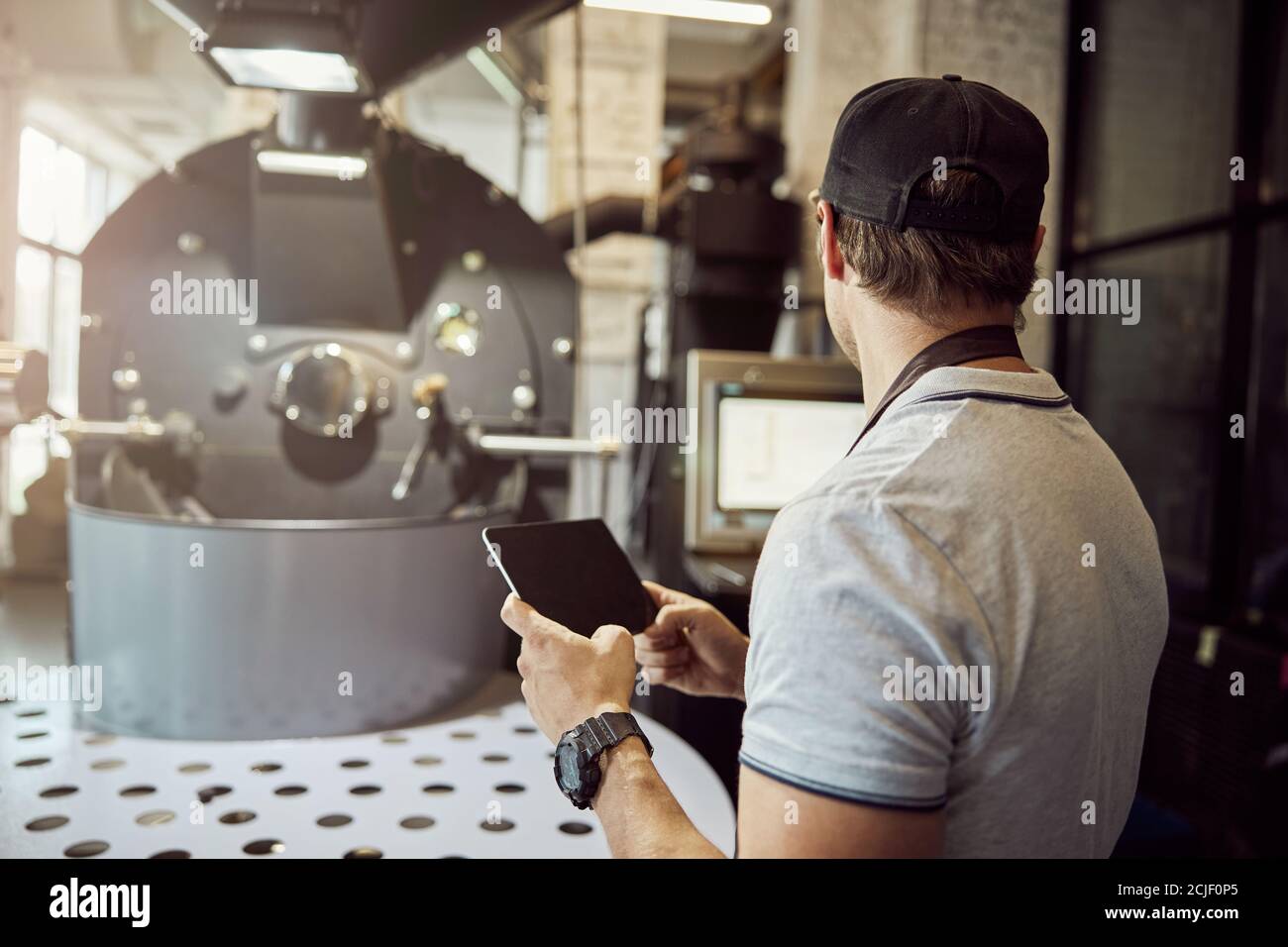 Male worker controlling work of coffee roasting machine Stock Photo Alamy