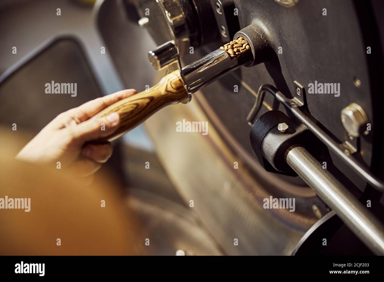 Male worker using industrial coffee roasting machine Stock Photo