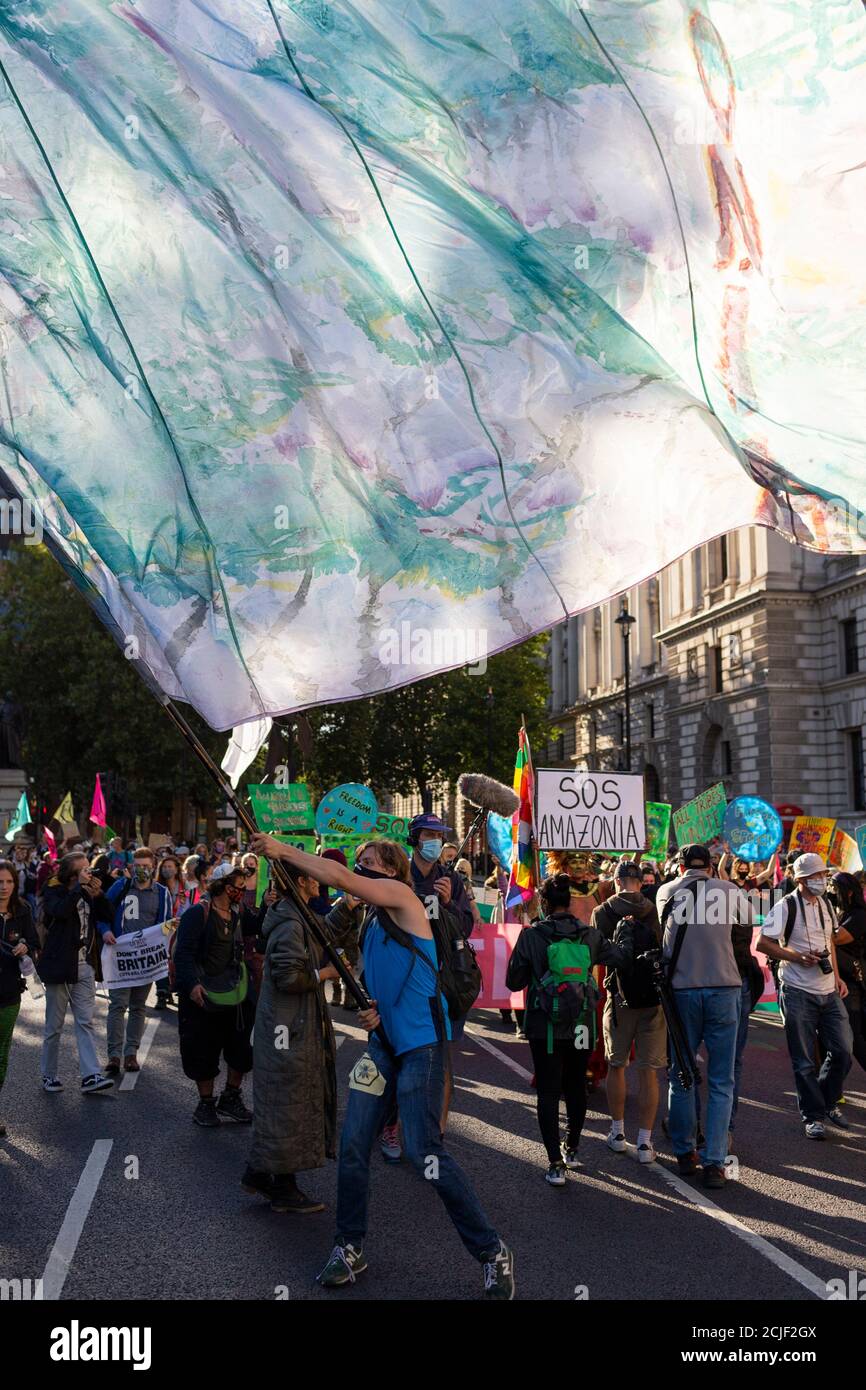 Flag waved above crowd, 'Rebels for Amazonia' Extinction Rebellion march on Indigenous Womens Day, London, 5 September 2020 Stock Photo