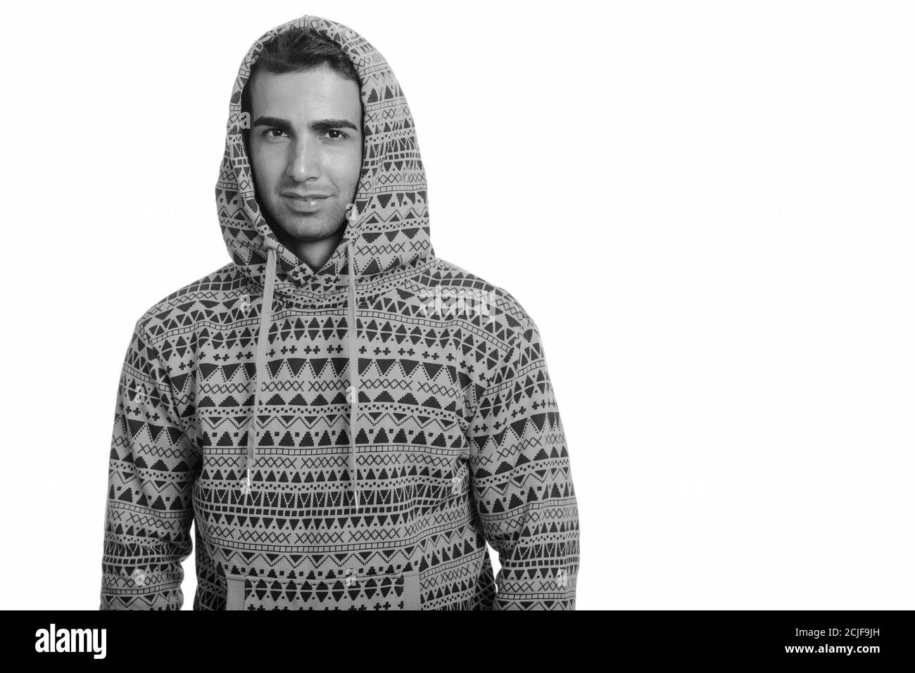 Studio shot of young handsome Persian man wearing hoodie Stock Photo