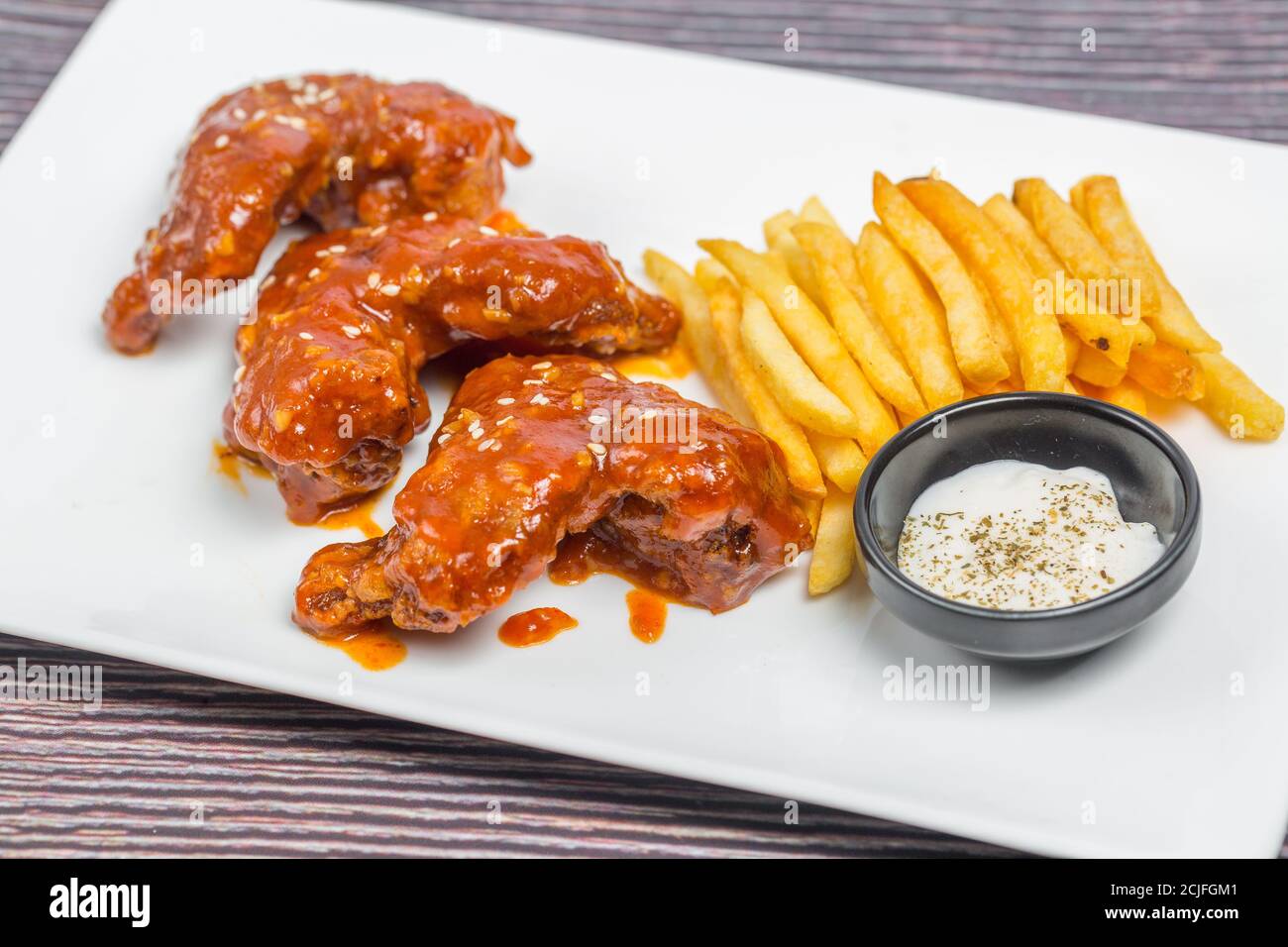 Hot and spicy buffalo chicken wings and crispy french fries with white