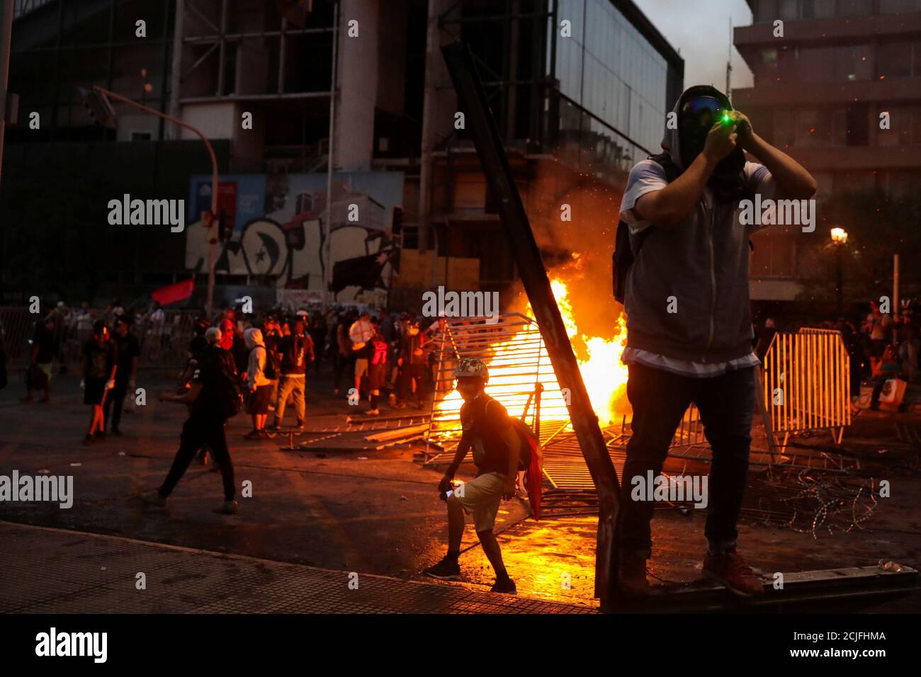 A demonstrator uses a laser pointer near a barricade on fire during a  protest against Chile's government, in Santiago, Chile November 22, 2019.  REUTERS/Pablo Sanhueza Stock Photo - Alamy
