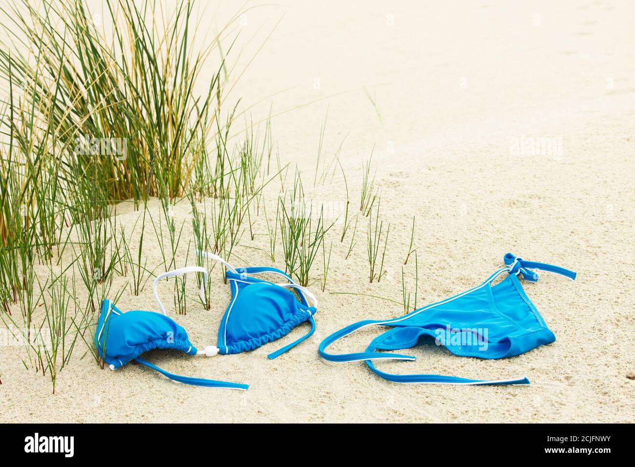 Nudist beach. Bikini swimsuit on sand at the beach Stock Photo