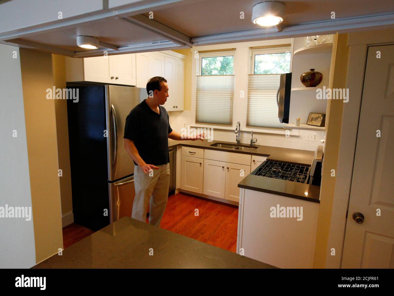 Real estate investor Lance Young describes to visitors the kitchen renovations that he has done in one of the distressed houses that he has purchased to renovate and resell in the Washington suburb of Arlington, Virginia, June 29, 2011. Young buys several discounted or distressed houses a year and then tries to make a substantial profit after performing major renovations on them. Often blamed for helping to create the U.S. housing boom and crash by driving up prices, investors are now welcomed as a key support for the battered property market. Picture taken June 29, 2011. To match Feature USA- Stock Photo
