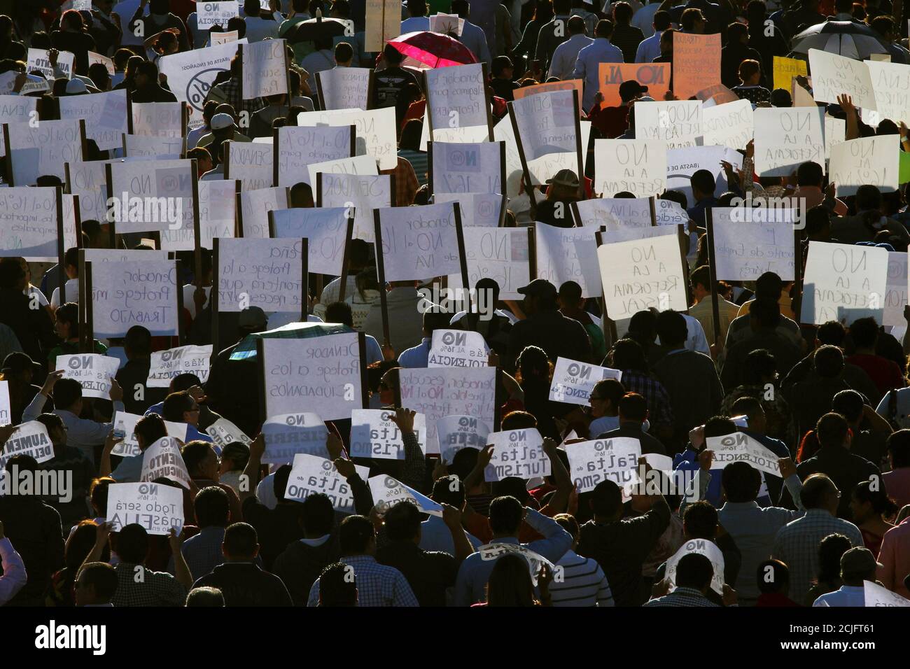 Demonstrators hold up signs during a march against the federal government's economic and tax reforms in Ciudad Juarez October 22, 2013. The Lower House maintained the government's plan to raise the lower 11 percent value-added tax (VAT) rate for border states to match the national rate of 16 percent.  REUTERS/Jose Luis Gonzalez (MEXICO  - Tags: BUSINESS SOCIETY POLITICS CIVIL UNREST) Stock Photo