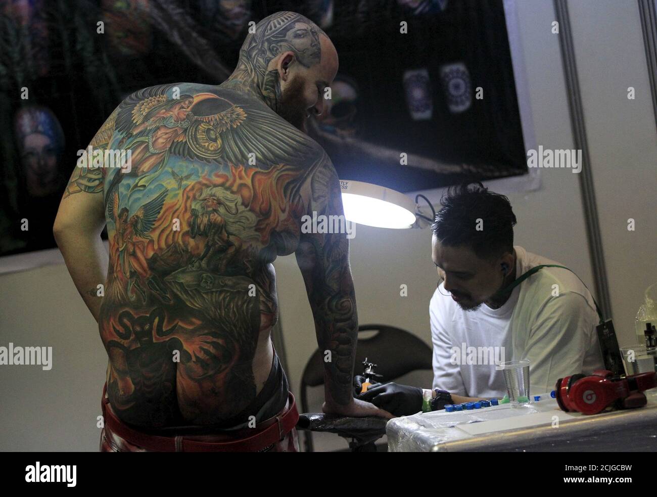 Details of the tattoos on a man's back are seen as he receives another on his hand during the annual tattoo exposition Details of the tattoos on a man's back are seen as he receives another on his hand during the annual tattoo exposition