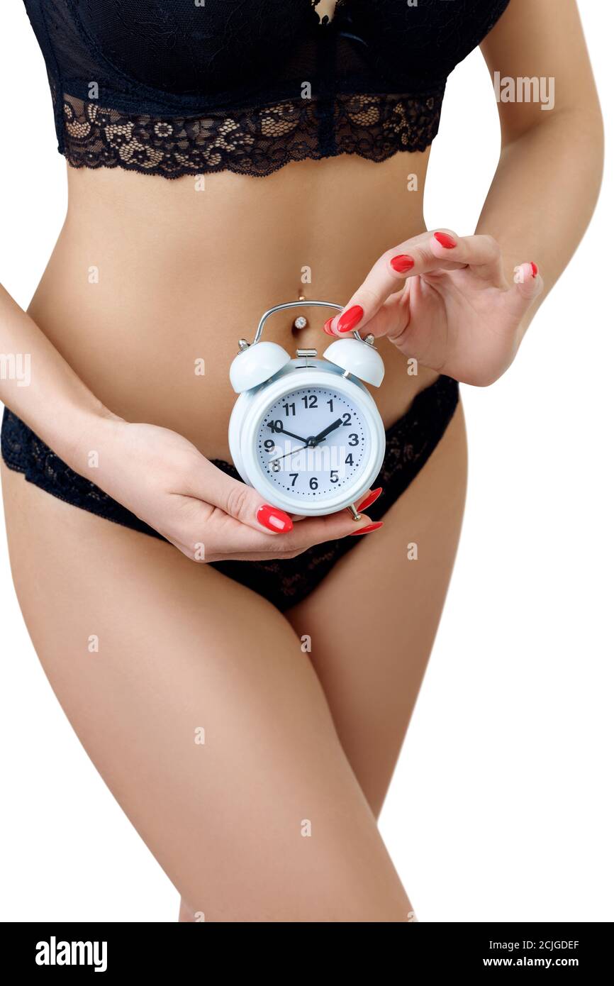 Woman in black panties holding alarm clock in hands. Stock Photo