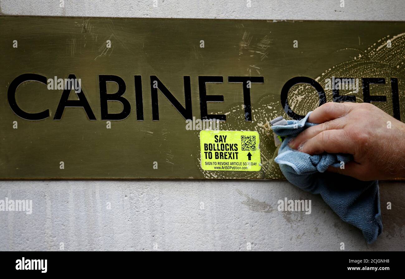 A worker removes anti-Brexit stickers from a sign at the Cabinet Office in London, Britain July 22, 2019.  REUTERS/Henry Nicholls Stock Photo