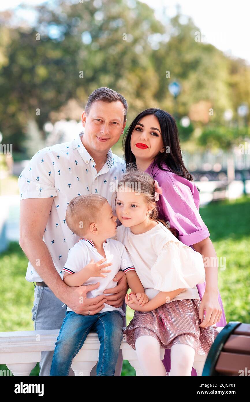 Happy young family with two kids walking in the park. Happy parenting concept Stock Photo