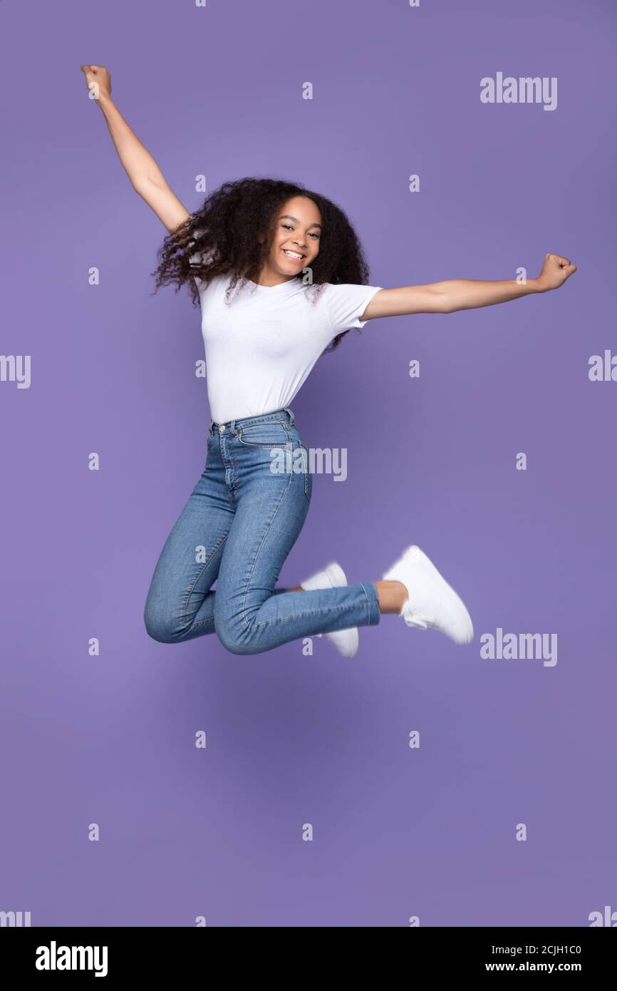 Happy African American Woman Jumping Posing In Mid-Air, Purple