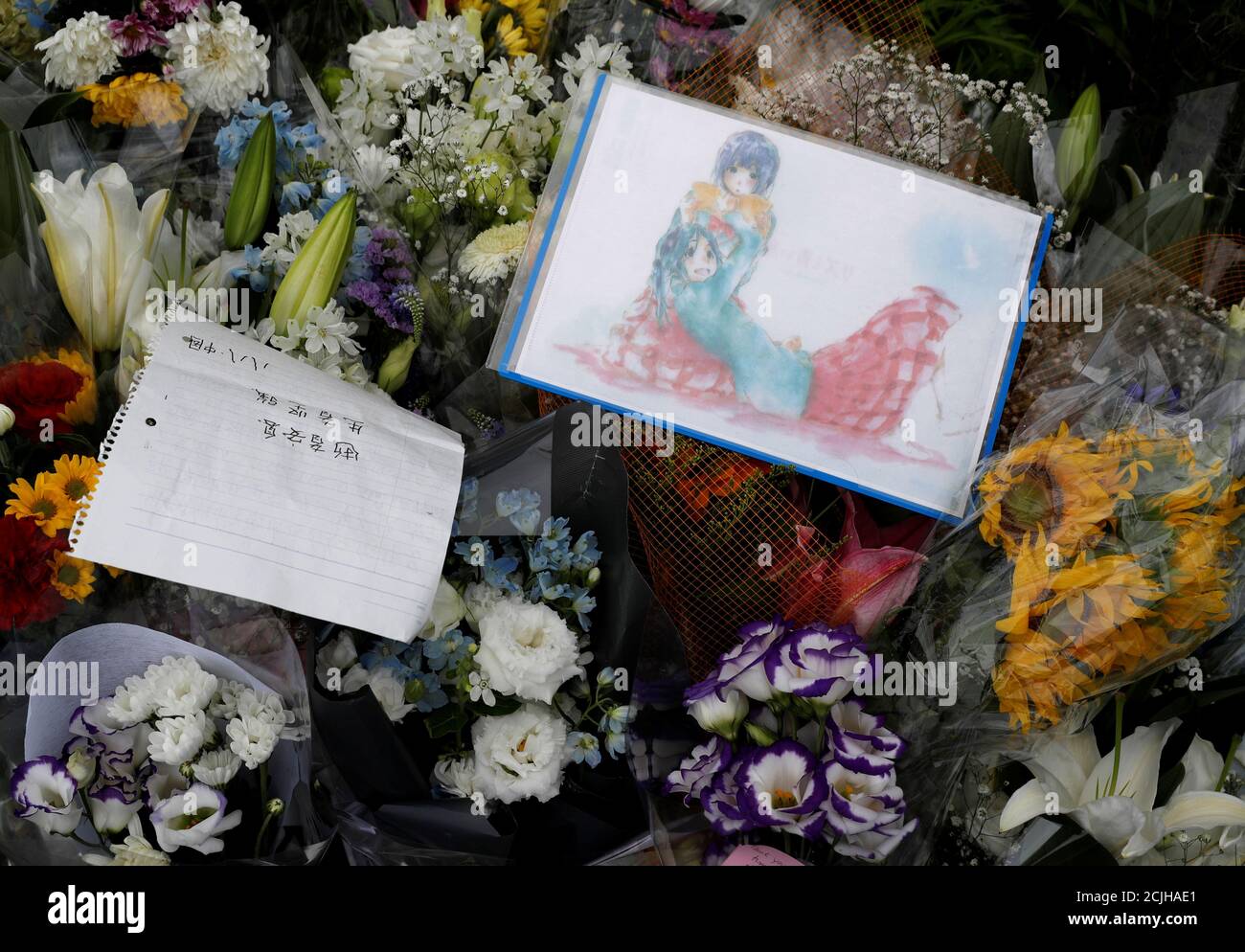 Flowers and a drawing with anime characters dedicated to the victims of the fire are seen left outside the Kyoto Animation building which was torched by arson attack, in Kyoto, Japan, July Flowers and a drawing with anime characters dedicated to the victims of the fire are seen left outside the Kyoto Animation building which was torched by arson attack, in Kyoto, Japan, July