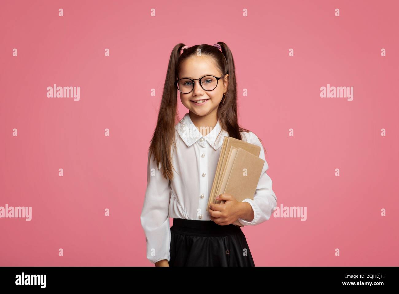 School and education. Smiling pupil in uniform and glasses holding books Stock Photo