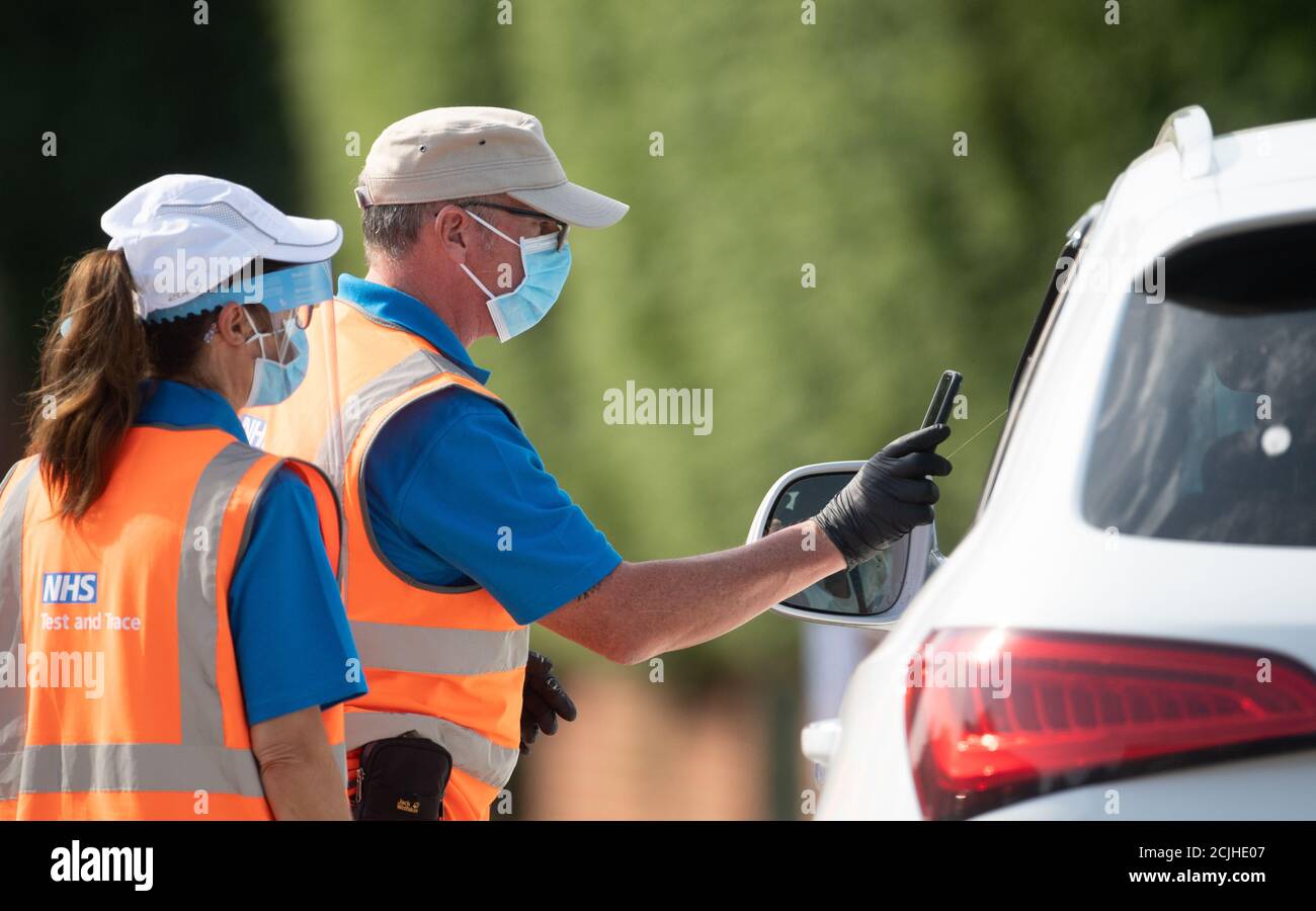 Staff scan the barcode on a coronavirus test through a car window at a mobile Covid-19 testing centre in Peterborough. Stock Photo