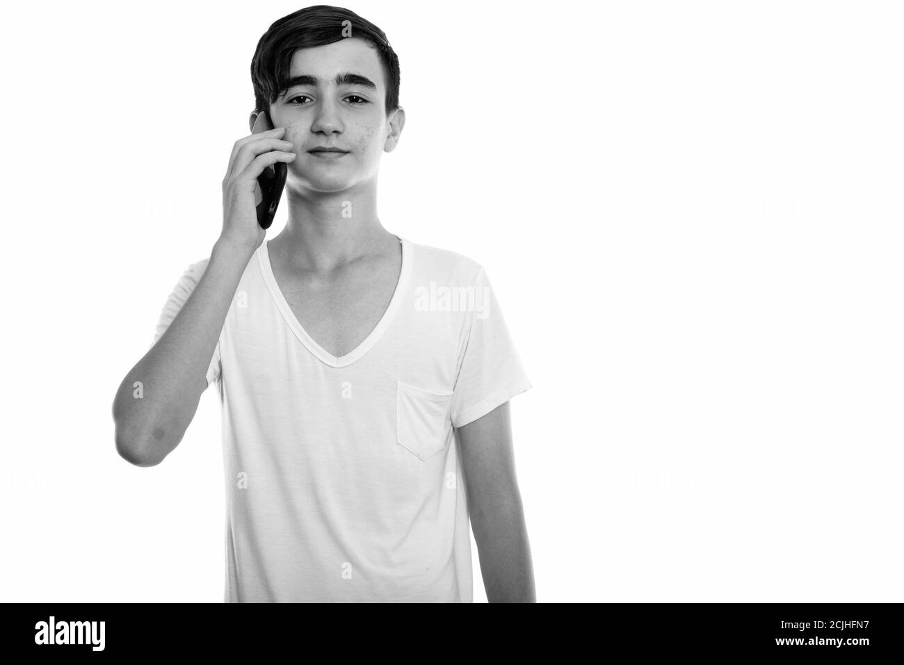 Studio shot of young handsome Persian teenage boy talking on mobile phone Stock Photo Alamy